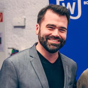 Lächelnder Mann bei Westie Community Treffen, Suche nach West Coast Swing Tänzern, Events und Gemeinschaft.